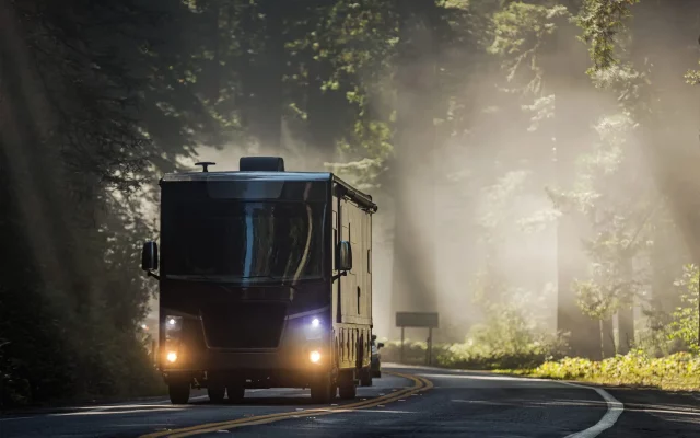 Class A Diesel Pusher Motorhome RV on a Scenic California Highway 101 Covered by Coastal Fog. Motor Coach Road Trip Vacation.