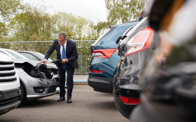 Male Insurance Loss Adjuster With Digital Tablet Inspecting Damage To Car From Motor Accident Male Insurance Loss Adjuster With Digital Tablet Inspecting Damage To Car From Motor Accident