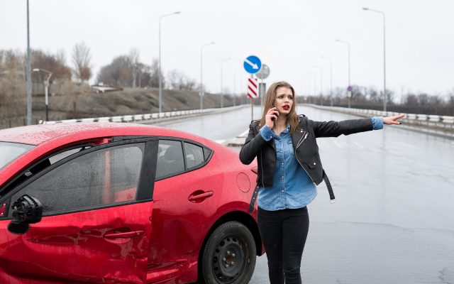 Woman calls to a service standing by a red car. Beautiful woman Woman calls to a service standing by a red car. Beautiful woman catches the car